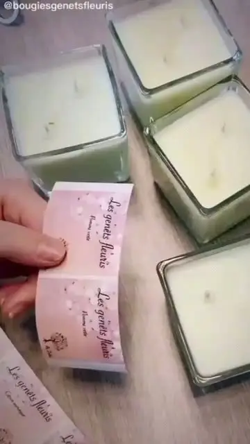 Étiquettes roses tenues au-dessus de bougies en pots de verre