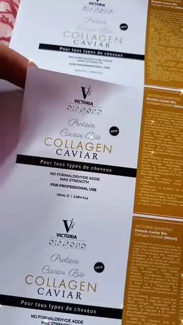 Étiquettes blanches et dorées d’un produit capillaire, tenues à la main